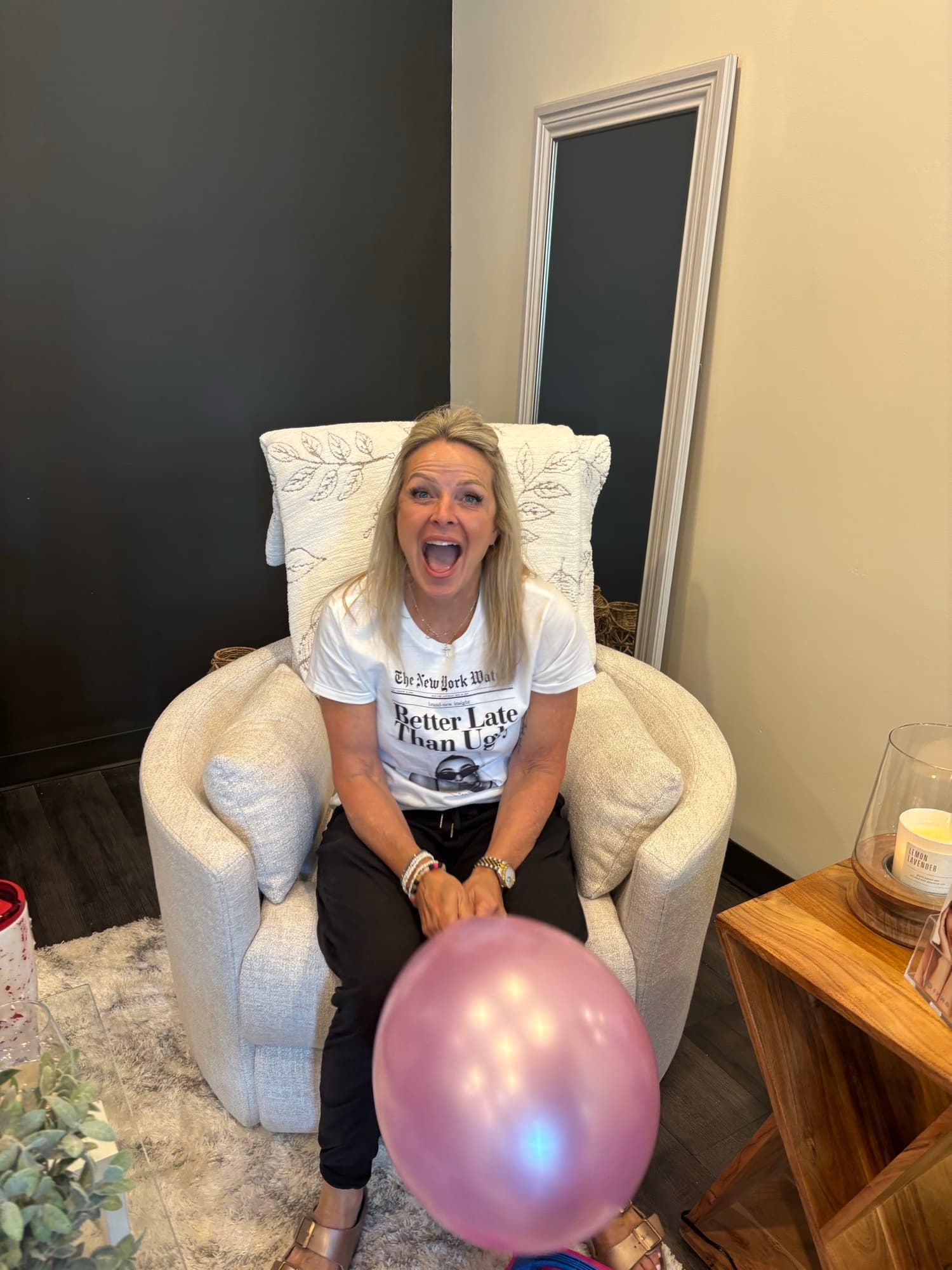 Danielle celebrating in the downtown Oswego studio with a rose-gold balloon