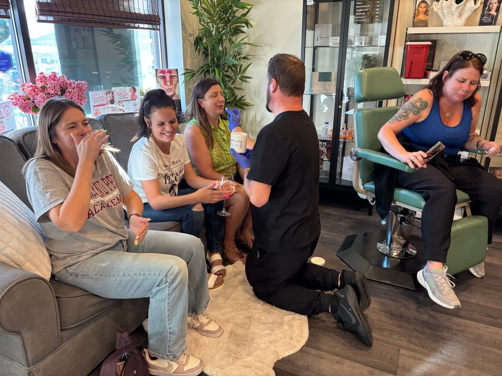 Event night in the new Washington Street studio — lounge, treatment chair, and friends